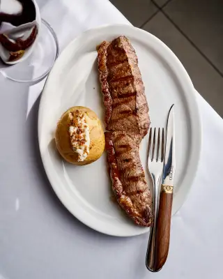 Corte grelhado com batata assada servido em prato branco